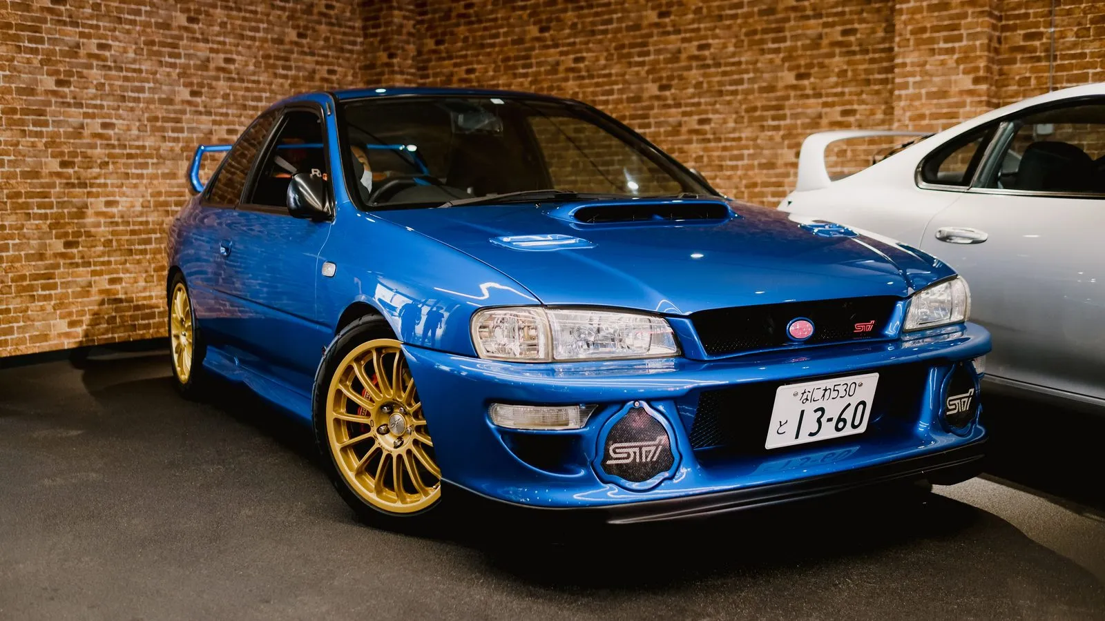 Subaru Impreza 22B STI azul Sonic Blue con carrocería ancha y llantas doradas